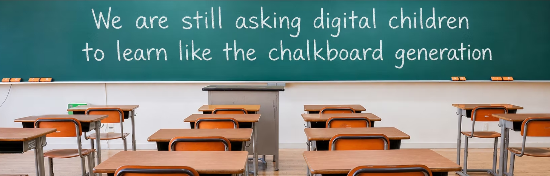 An empty classroom. Written on the chalkboard: We are still asking digital children to learn like the chalkboard generation.